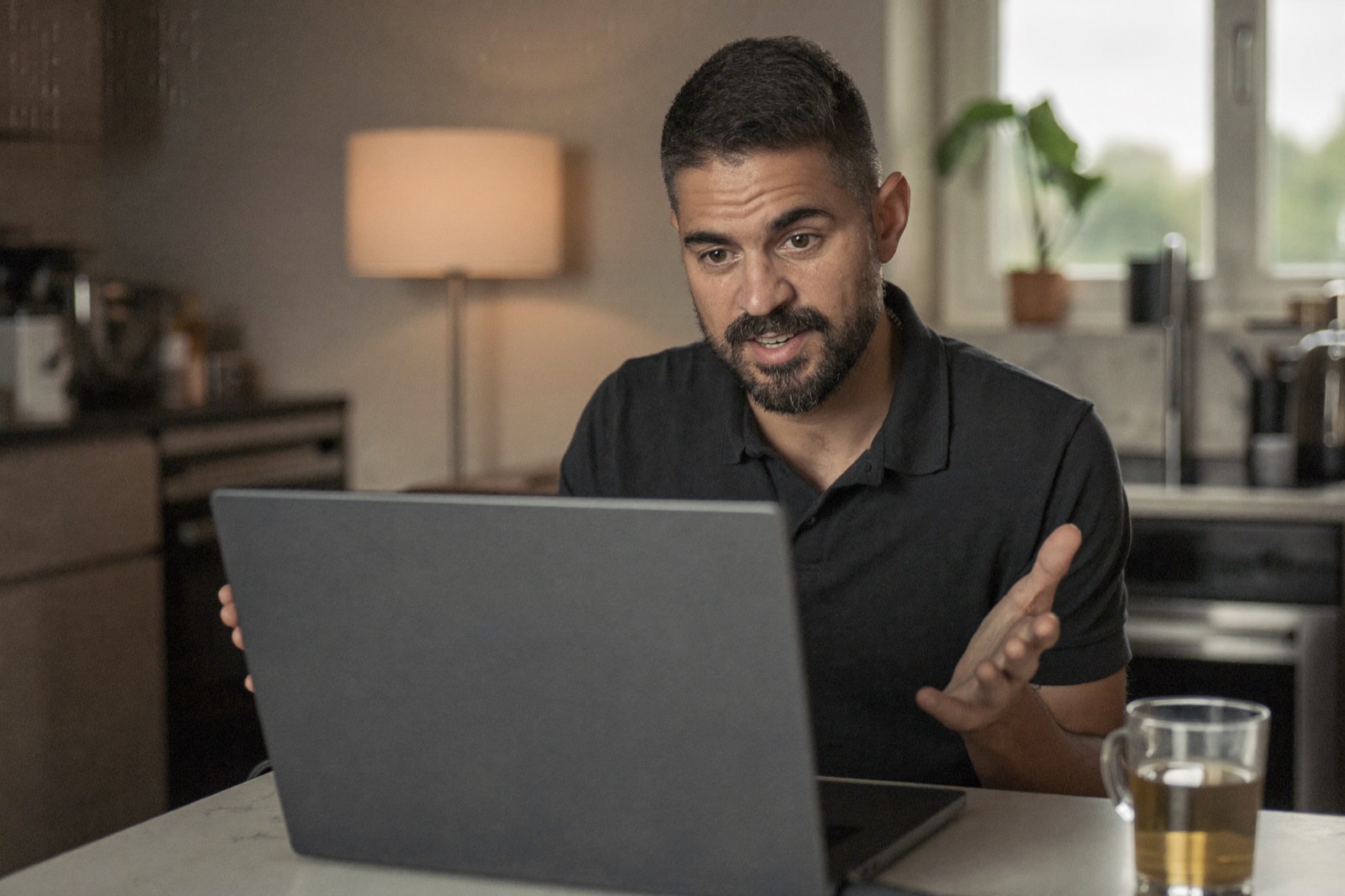 A candidate speaking to his laptop while taking an Attest English assessment at home